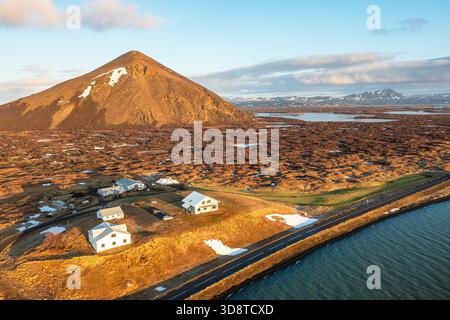 Vue aérienne de Sertingoflj Get Mountain en Islande avec des maisons rurales et des bâtiments de recherche de style expédition près de la route côtière. Banque D'Images