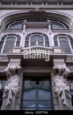 Vue rapprochée de la façade du Théâtre Sébastopol montrant des vitraux, des ornements architecturaux détaillés et deux figures masculines sculptées supportant Banque D'Images