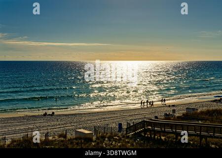 Les gens marchant sur une plage côtière du golfe d'Amérique Floride près de destin, Floride USA, près du coucher du soleil. Banque D'Images