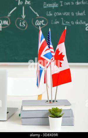 Différents drapeaux avec des livres sur la table dans la salle de classe anglaise Banque D'Images