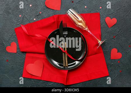 Table de réglage pour la Saint-Valentin avec des coeurs en papier et serviette rouge sur fond sombre Banque D'Images