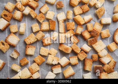 Beaucoup de croûtons croquants sur papier cuisson, gros plan Banque D'Images