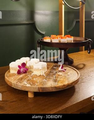 Morceaux de gâteau à la noix de coco et cheesecake avec gelée de fruits sur des assiettes décoratives. Mise au point sélective. Banque D'Images