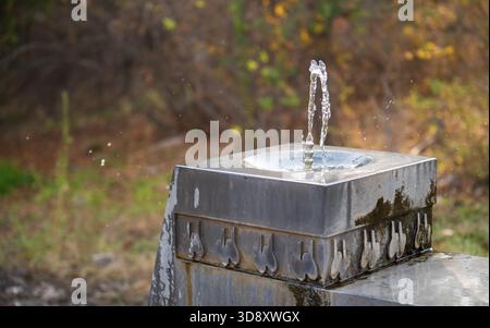 Une fontaine avec de l'eau qui en sort. L'eau est projetée hors de la fontaine et sur le sol Banque D'Images