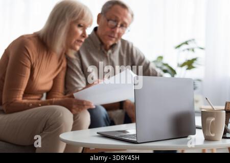 Examinez ensemble des documents en couple tout en étant assis dans leur salon pendant l'après-midi Banque D'Images