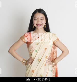 Portrait de fille indienne confiante en sari souriant sur fond gris Banque D'Images