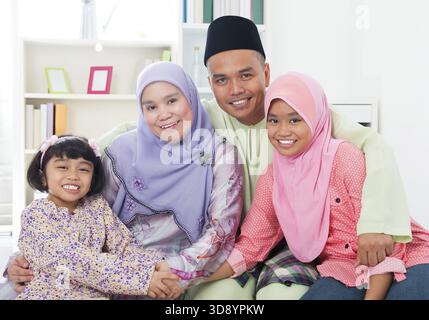 Heureuse famille asiatique à la maison. Famille musulmane s'amusant à l'intérieur. Parents et enfants d'Asie du Sud-est souriants Banque D'Images