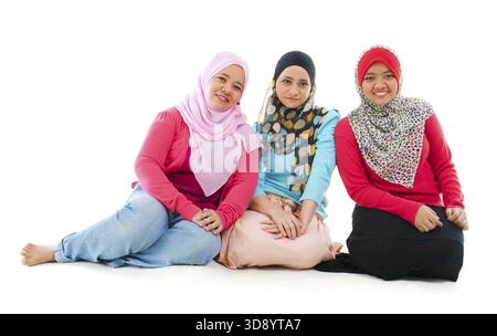 Portrait de trois femmes musulmanes joyeux assis sur fond blanc Banque D'Images