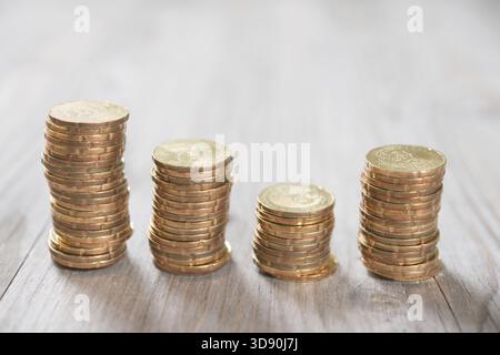 Les pièces de monnaie empilent dans la rangée sur fond en bois, concept financier. Effectuez la mise au point sur le premier plan avec un arrière-plan flou Banque D'Images