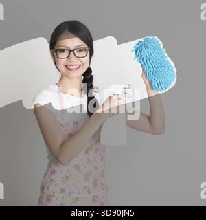 Femme au foyer asiatique jeune nettoyage, essuyez le verre sale Banque D'Images