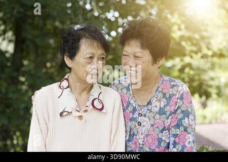 Cliché franc de femmes âgées asiatiques parlant au parc extérieur le matin Banque D'Images