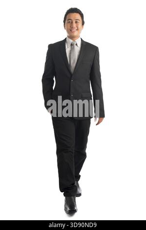 Corps plein attrayant jeune homme d'affaires d'Asie du Sud-est marchant, isolé sur fond blanc. Modèle masculin malais asiatique Banque D'Images