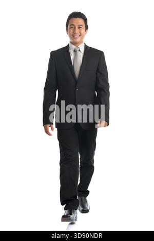 Corps plein attrayant jeune homme d'affaires d'Asie du Sud-est marchant, isolé sur fond blanc. Modèle masculin malais asiatique Banque D'Images