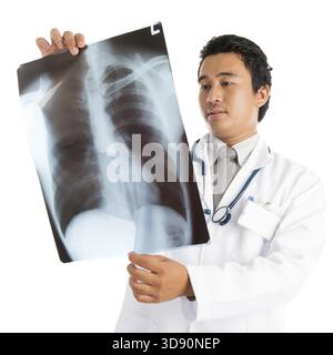Attrayant jeune médecin masculin d'Asie du Sud-est examinant l'image de balayage de rayons X, debout isolé sur fond blanc Banque D'Images