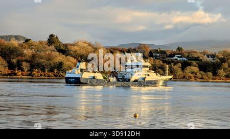 Un bateau côtier naviguant à travers le Loch Etive sous la lumière dorée chaude de l'après-midi Banque D'Images
