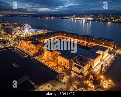 LIVERPOOL, MERSEYSIDE, ANGLETERRE - 21 NOVEMBRE 2025 : vue aérienne de nuit du Royal Albert Dock avec la grande roue illuminée à côté de la rivière Mersey, Banque D'Images