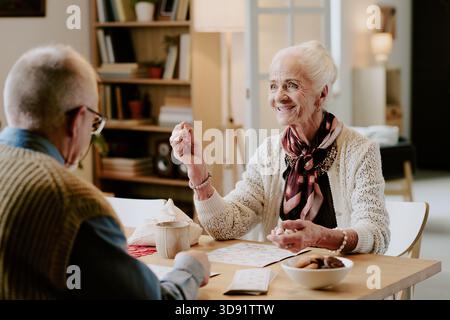 Femme senior souriant tout en jouant Game With Senior Man Banque D'Images