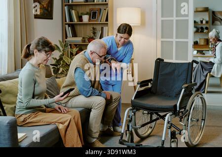 Femme d'âge moyen aidant homme âgé handicapé Banque D'Images