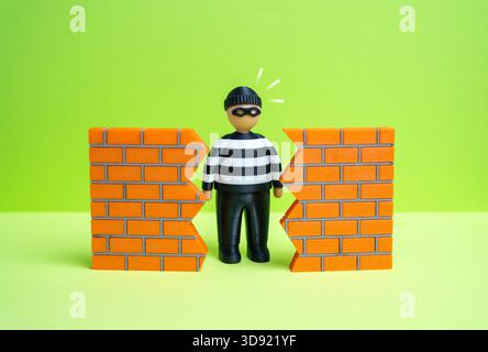 Un criminel trouve un trou dans le mur. Le concept de détection d'une vulnérabilité dans la sécurité. Faiblesses du système et risques de violation. Cybersécurité, loi enforc Banque D'Images