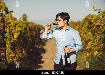 Homme buvant du vin rouge dans Vineyard Banque D'Images