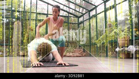 Instructeur en tenue rose-sarcelle aidant l'élève en yoga pose en serre sur tapis noir, grille binaire Banque D'Images