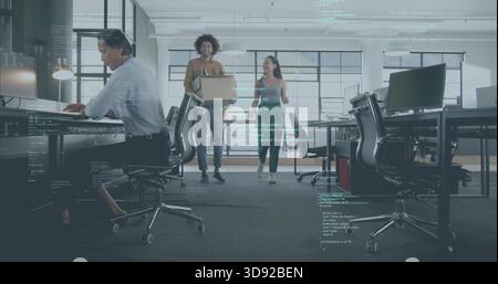 Des collègues qui se promènent dans une tenue décontractée tenant un ordinateur portable, qui passent devant un bureau avec superposition de code Banque D'Images