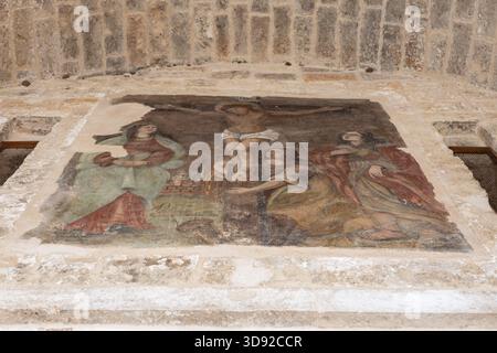fresque vieillie et détériorée représentant la crucifixion de jésus-christ avec la vierge marie et saint jean l'évangéliste, peinte sur un mur de pierre à ita Banque D'Images