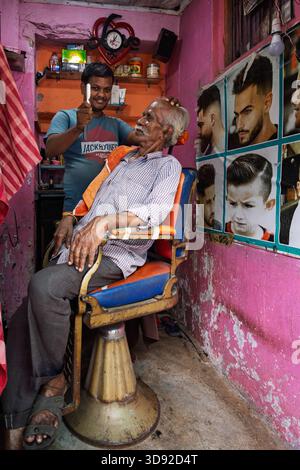 Homme âgé se rasant dans un salon de coiffure, Puri, Odisha, Inde Banque D'Images