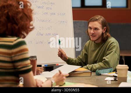 Jeune homme expliquant la leçon de langue à la jeune femme Banque D'Images
