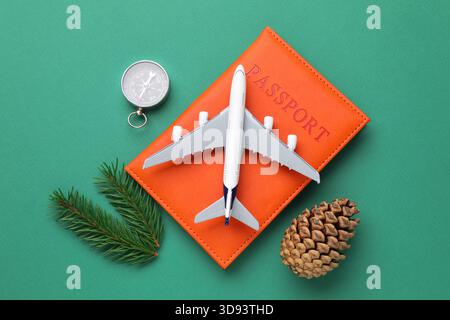 Vacances de Noël. Passeport, avion jouet, boussole et décor sur fond turquoise, pose plate Banque D'Images