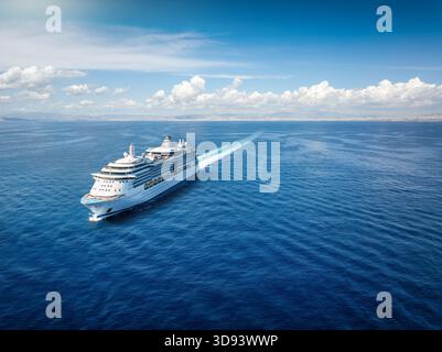 Vue aérienne de face d'un bateau de croisière générique naviguant avec vitesse au-dessus de l'océan calme avec espace de copie Banque D'Images