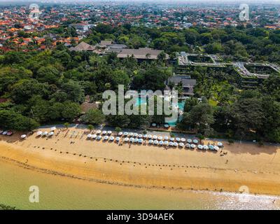 Drone shot surplombant une plage de sable, un lieu de villégiature et la ville de Sanur à Bali Banque D'Images