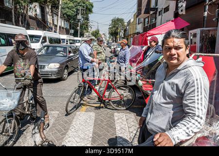 Mexico Mexique, Xochimilco, scène de rue les cyclistes hommes adultes se sont rassemblés parlant, homme adulte premier plan regardant la caméra, voitures de congestion de la circulation vans, RID Banque D'Images
