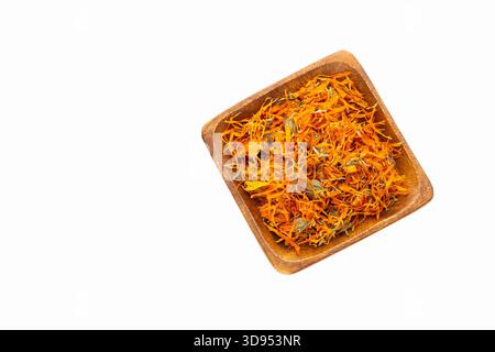 Fleurs de calendula séchées dans un récipient en bois sur fond blanc - Calendula officinalis Banque D'Images