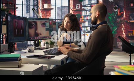Graphiste et photographe collaborent dans un studio moderne, à l'aide d'un logiciel de retouche photo basé sur l'IA sur PC. Fournir des outils d'automatisation, de retouche et de réglage avancé de l'image. Caméra A. Banque D'Images