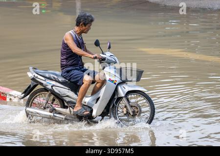 BANGKOK, THAÏLANDE, nov 09 2025, Une moto roule dans une rue inondée, Thaïlande Banque D'Images