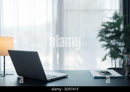 Lieu de travail de bureau avec ordinateur portable et téléphone intelligent sur la table en bois. Espace de travail, ordinateur de bureau, fournitures de bureau, plante d'intérieur et livres au bureau. bureau co Banque D'Images