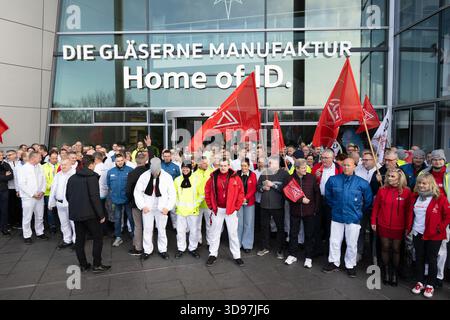 Dresde, Allemagne. 04th Dec, 2025. Les participants à un rallye organisé par IG Metall Dresde se tiennent sur la terrasse de la Volkswagen transparent Factory après la réunion de travail. La production du modèle électrique ID.3 à l’usine transparente, qui emploie environ 320 personnes, sera interrompue à la fin de l’année. Crédit : Sebastian Kahnert/dpa/Alamy Live News Banque D'Images