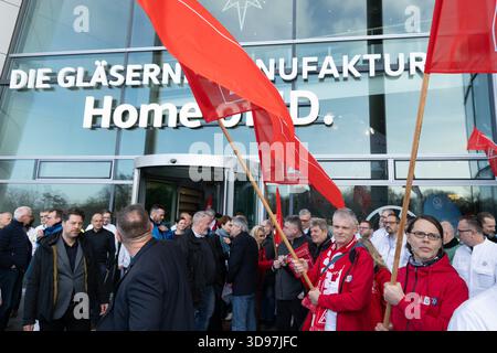 Dresde, Allemagne. 04th Dec, 2025. Les participants à un rallye organisé par IG Metall Dresde se tiennent sur la terrasse de la Volkswagen transparent Factory après la réunion de travail. La production du modèle électrique ID.3 à l’usine transparente, qui emploie environ 320 personnes, sera interrompue à la fin de l’année. Crédit : Sebastian Kahnert/dpa/Alamy Live News Banque D'Images