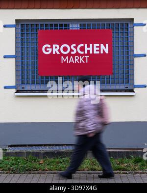 Dresde, Allemagne. 04th Dec, 2025. Une femme passe devant un panneau "Groschen-Markt". La société derrière le détaillant Groschen-Markt a déposé une procédure de faillite. Crédit : Robert Michael/dpa/Alamy Live News Banque D'Images