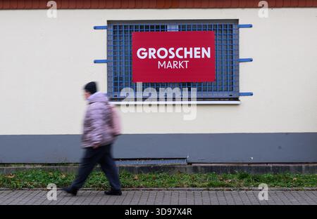 Dresde, Allemagne. 04th Dec, 2025. Une femme passe devant un panneau "Groschen-Markt". La société derrière le détaillant Groschen-Markt a déposé une procédure de faillite. Crédit : Robert Michael/dpa/Alamy Live News Banque D'Images