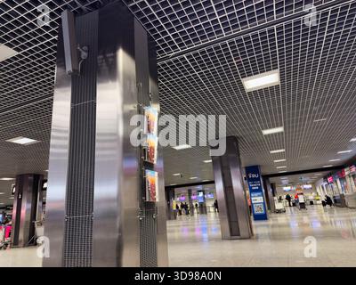 Cracovie, Pologne - 07 novembre 2025 : vue panoramique d'un hall d'aéroport polonais de Cracovie avec colonnes en acier, plafond grillagé, affiches et voyageurs. Banque D'Images