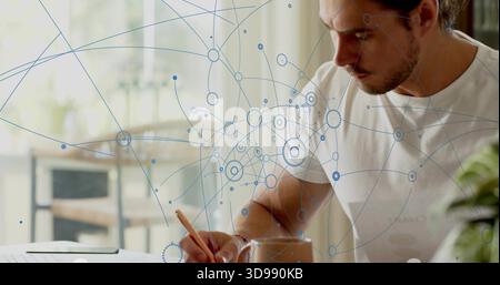 Homme d'écriture portant T-shirt blanc se concentrant sur le crayon et le papier à la maison, tasse d'ordinateur portable, espace de copie Banque D'Images