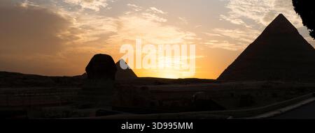 Le grand sphinx et les pyramides sous un soleil éclatant. Vue panoramique sur le plateau de Gizeh avec les grandes pyramides et le sphinx le soir au coucher du soleil Banque D'Images