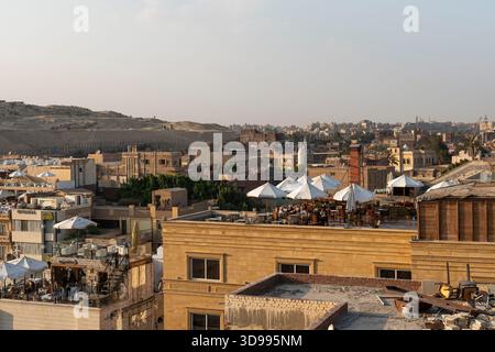 Restaurants sur les toits de maisons près des grandes pyramides de Gizeh. Les touristes apprécient la vue magnifique tout en dînant dans un café. 18 octobre 2022. Gizeh, Banque D'Images