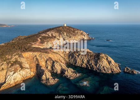 La côte sauvage de l'île dispose d'une petite tour au sommet d'une colline rocheuse, surplombant l'océan bleu calme, Sardaigne, Italie Banque D'Images