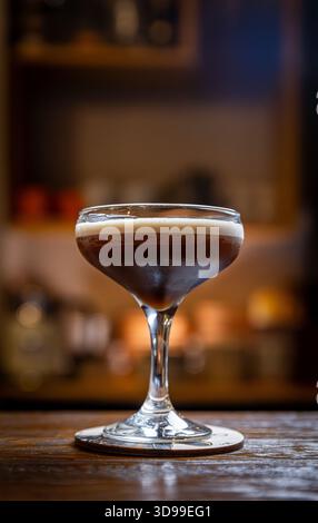 Cocktail espresso martini avec mousse sur un comptoir de bar Banque D'Images