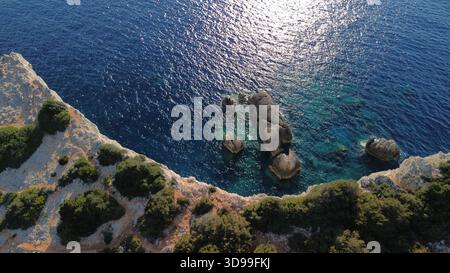 Plage vue aérienne d'une côte rocheuse avec une eau turquoise limpide et des formations rocheuses côtières dispersées en plein soleil. Banque D'Images