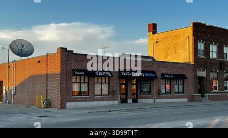 ROSEAU, MN - 21 juillet 2025 : bâtiment en brique avec une entreprise de communication est vu dans la lumière du soir dans la ville du nord du Minnesota. Banque D'Images