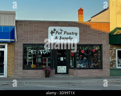 ROSEAU, MN - 21 juillet 2025 : busines locales d'approvisionnement pour animaux de compagnie dans le bâtiment en brique sur la rue principale dans la petite ville du nord du Minnesota au crépuscule. Banque D'Images